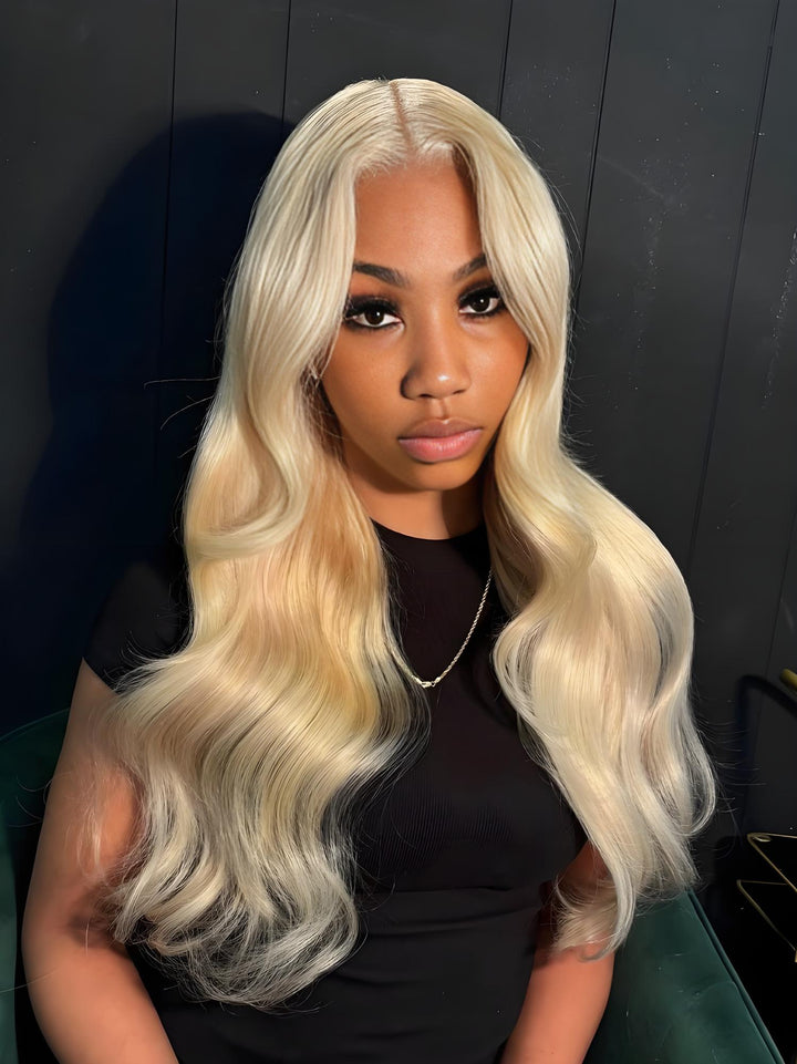 Close-up of a model wearing EuxmeHair 613 blonde body wave hair styled with a middle part and natural waves.