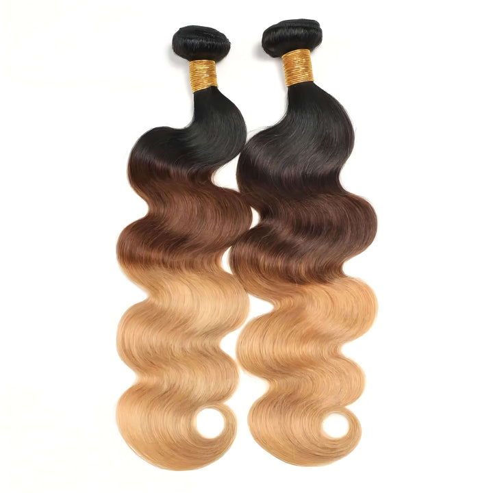 Two body wave bundles in T1B/4/27 ombre laid side by side, showing consistent curl pattern and vibrant honey blonde highlights.