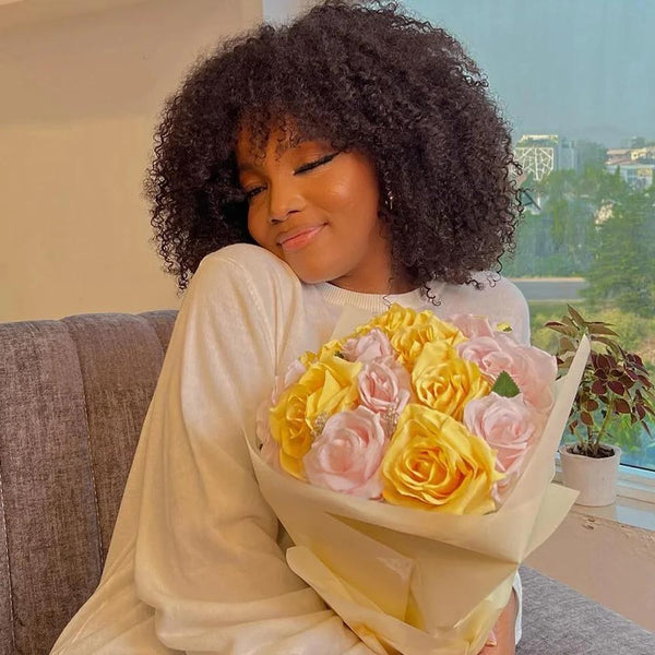 Close-up of tight afro curls on natural color full lace wig, highlighting defined pattern and softness.