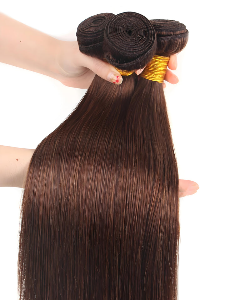 Close-up of a hand holding three bundles of silky straight brown hair, showing healthy strands and neat wefts.