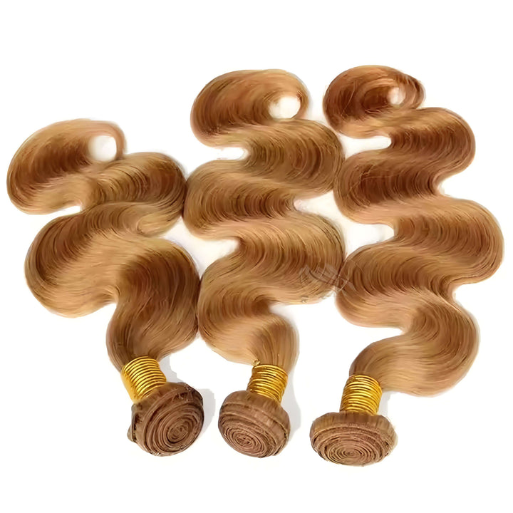 Three honey blonde body wave bundles laid flat on white background, showcasing natural wave texture and soft silky shine.