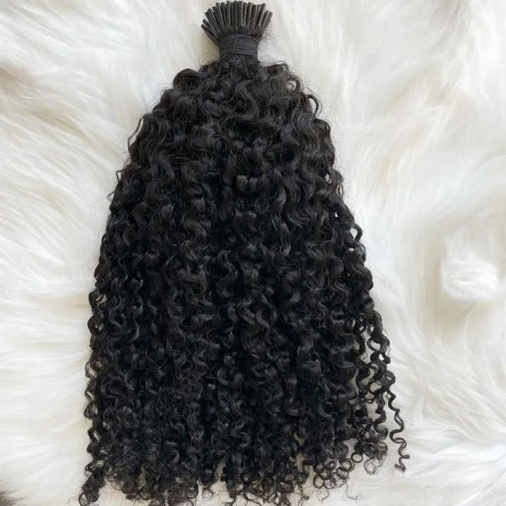 Single bundle of EuxmeHair I Tip Kinky Curly hair laid flat on white background, showcasing soft, natural sheen and coiled ends.