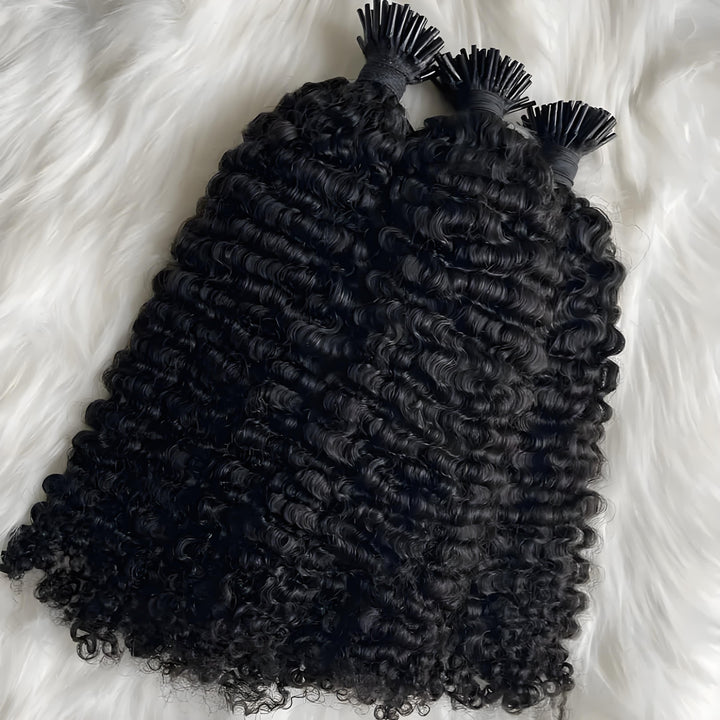 Three bundles of EuxmeHair I Tip Kinky Curly extensions displayed on white fur, highlighting thick ends and springy curls.