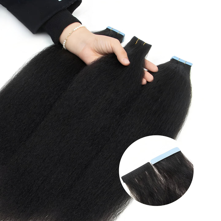 Close-up of hand holding kinky straight tape-in hair bundles, showing soft texture and adhesive tabs.