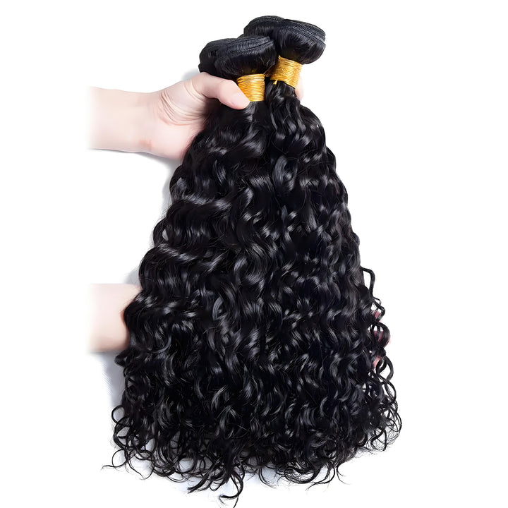 A hand holding several bundles of natural black water wave hair, highlighting thickness, shine, and curl pattern.