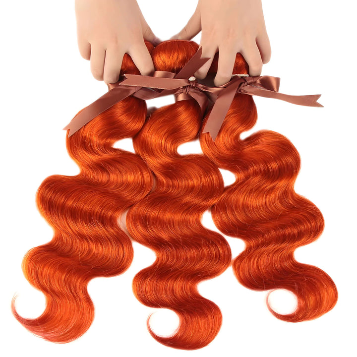 Orange body wave bundles tied with brown ribbons, shown being held by hands, soft flowing wave pattern.