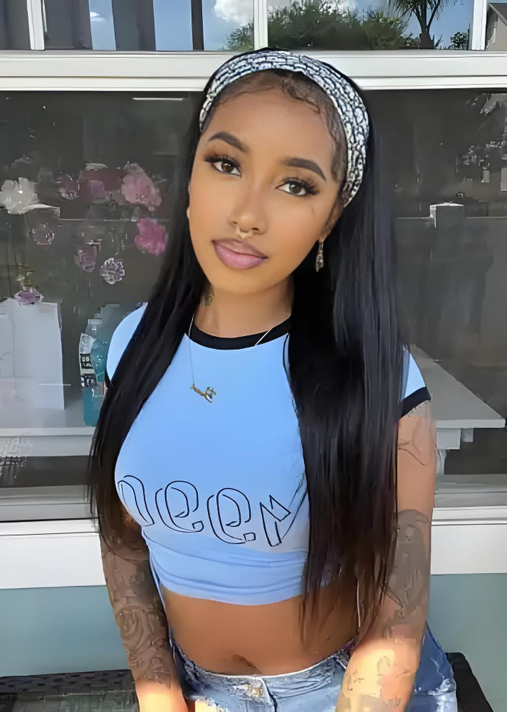 Model wearing long straight headband wig in natural color with blue crop top and patterned headband.
