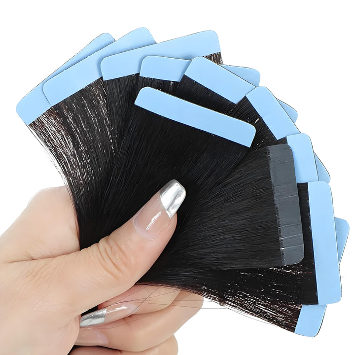 Close-up view of tape-in hair bundle with blue adhesive strips fanned in hand, showing neat construction and shine.