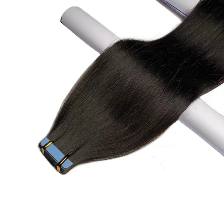 Tape-in straight hair extension bundle laid flat on white surface with blue adhesive tabs clearly visible.