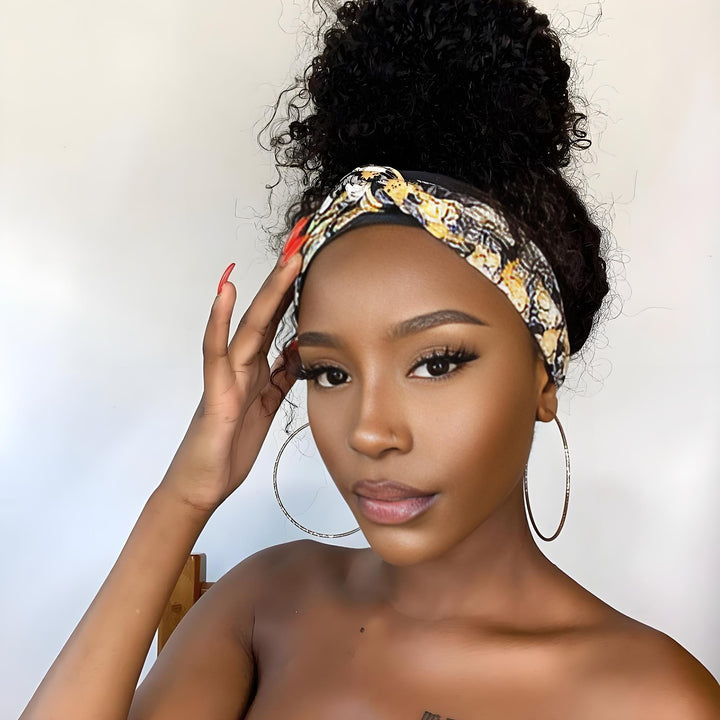 Top bun hairstyle created with water wave headband wig, worn with yellow and black floral band and natural baby hairs.