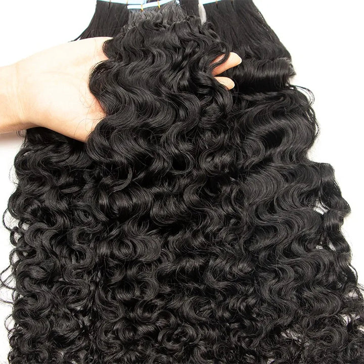 Close-up of natural color water wave texture showing defined S-shaped curls on tape in hair extensions.